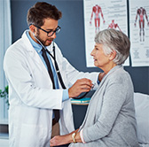 Doctor examining an older woman.
